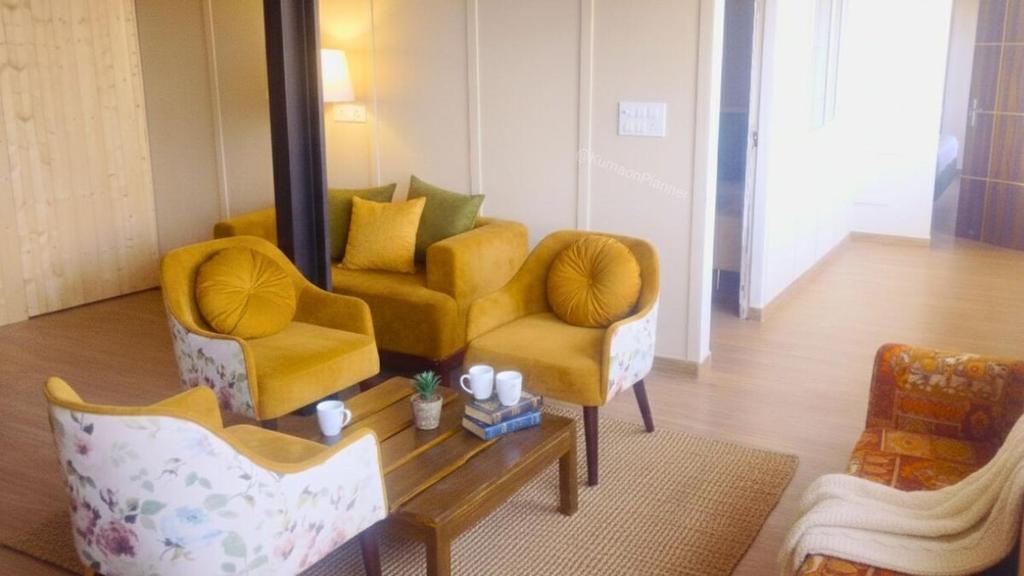 a living room with two chairs and a coffee table at Bhimtal Lakeview Cottage in Bhīm Tāl