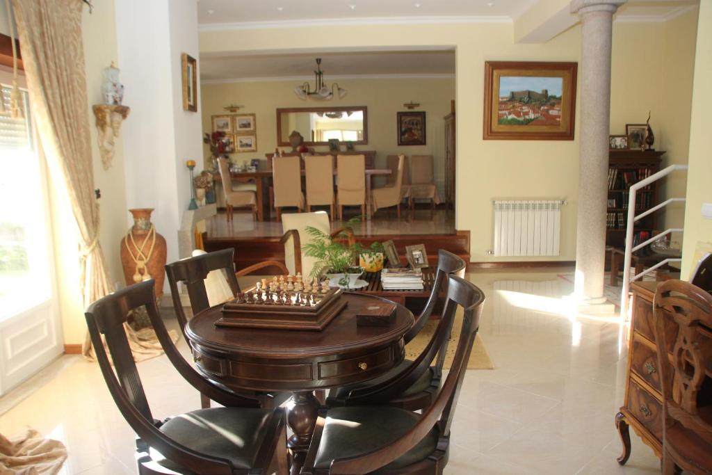 uma sala de jantar e sala de estar com mesa e cadeiras em Quartos em vivenda serra da Estrela em Celorico da Beira