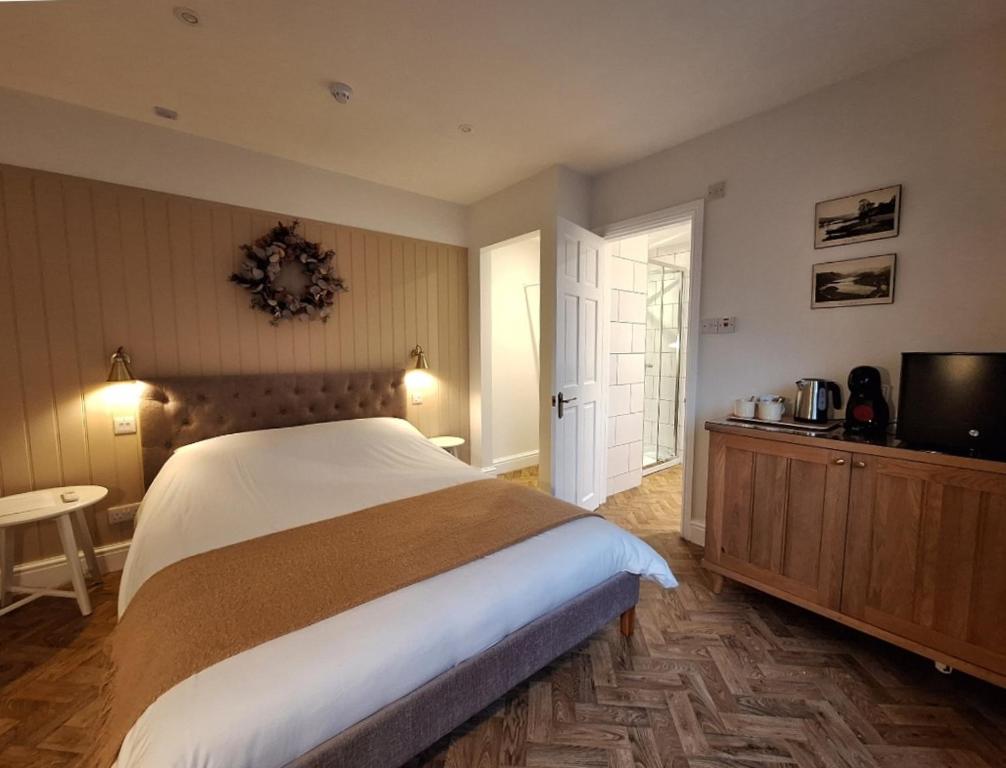 een slaapkamer met een groot bed en een televisie bij The Mews Room at The Coach House in Windermere