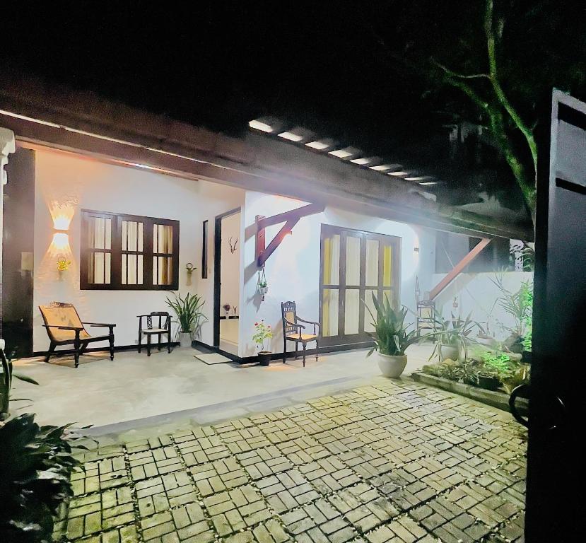 a patio of a house at night with chairs at Villa Senu in Ambalangoda