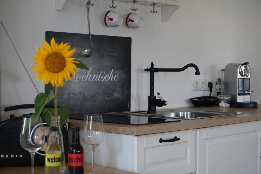 a kitchen with a table with a sunflower and a sink at Appartement Traunseeferien in Altmünster