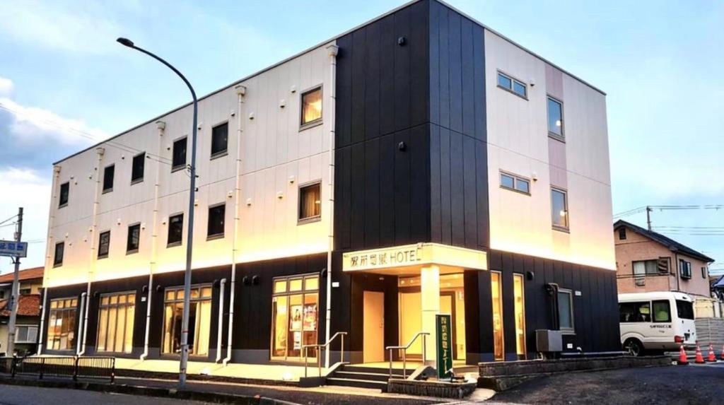 ein schwarzweißes Gebäude in einer Stadtstraße in der Unterkunft 阪南国际HOTEL in Hannan