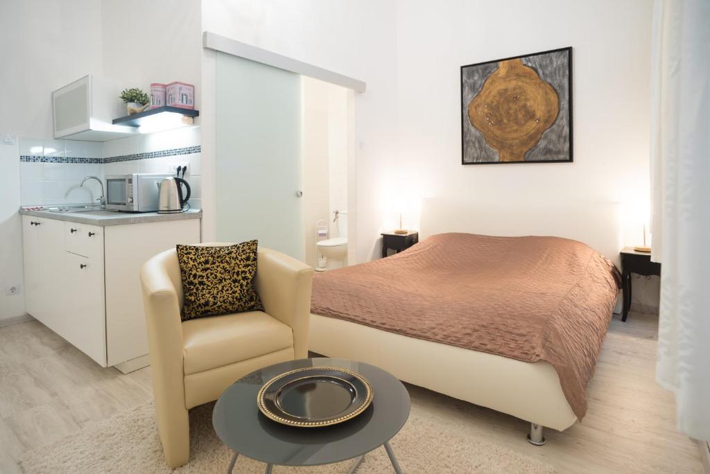 una camera con letto, sedia e tavolo di CLAUDIA Apartments Budapest a Budapest