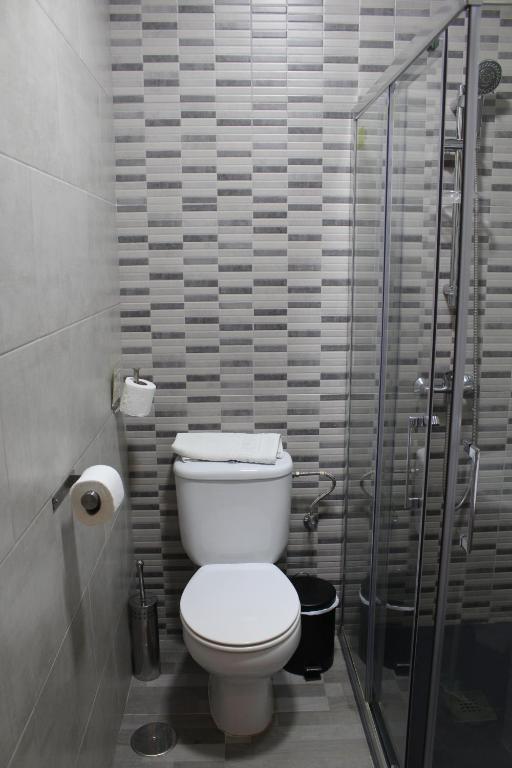 a bathroom with a toilet and a glass shower at Apartamentos Bolonia Paraiso in Bolonia