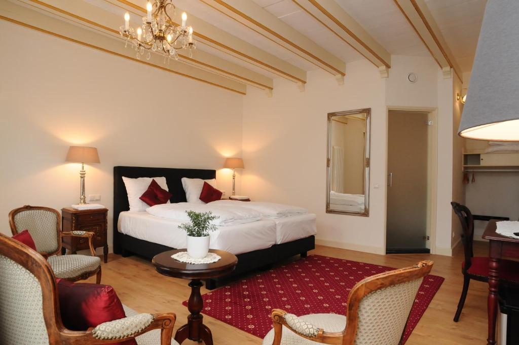 - une chambre avec un lit, une table et des chaises dans l'établissement Hotel De Gulden Waagen, à Nimègue