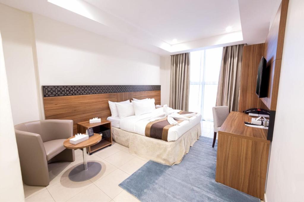 um quarto de hotel com uma cama, uma escrivaninha e uma TV em فندق ميزاب السابق 2 em Meca
