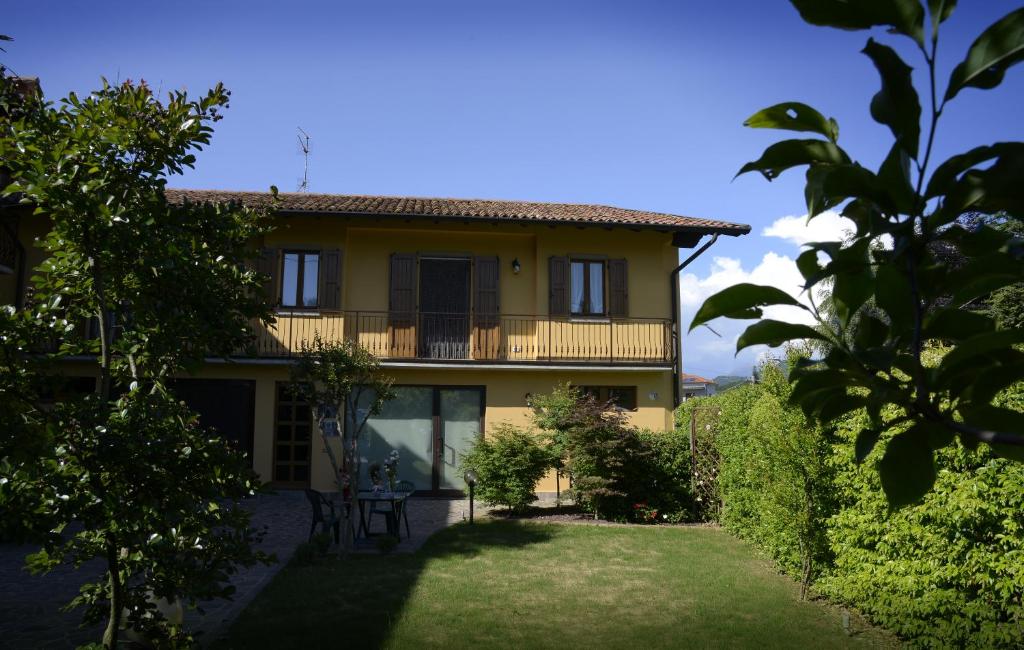 a large yellow house with a yard at Casa Vacanze Doralice in Barzana