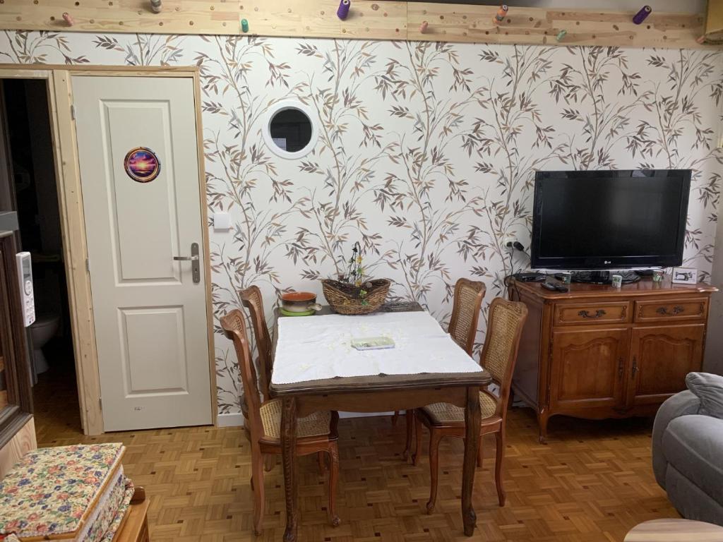 een woonkamer met een tafel en een tv bij atelier couture in Reiningue