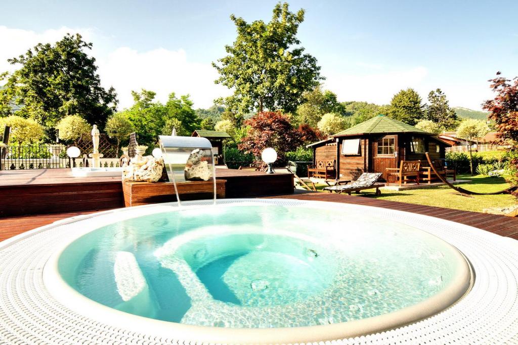 a hot tub in the middle of a backyard with a gazebo at Relais Antica Locanda La Diligenza in Borgo Pace