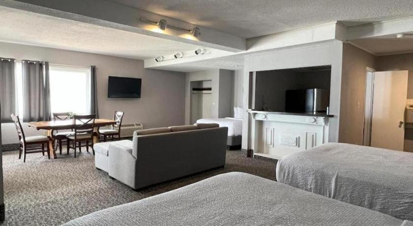 a hotel room with a bed and a dining room at The Georgian Resort in Lake George