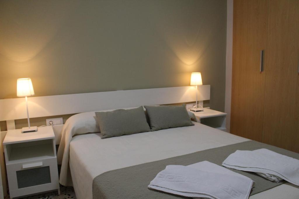 a bedroom with a large bed with two lights on at Apartamentos Bolonia Paraiso in Bolonia