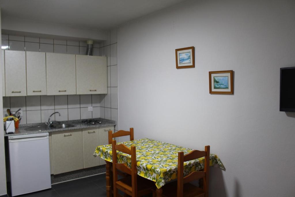 a small kitchen with a table and a sink at Apartamentos Bolonia Paraiso in Bolonia
