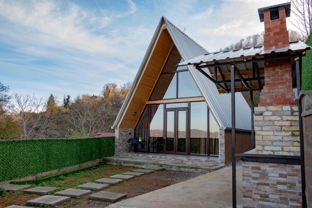 a house with a pitched roof with a glass extension at Aurarest - აურარესთ in Makho