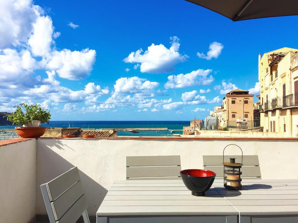 a table on a balcony with a view of the ocean at Corso Ventinove in Castellammare del Golfo