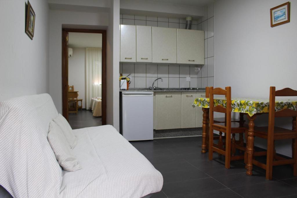 a living room with a kitchen and a table and chairs at Apartamentos Bolonia Paraiso in Bolonia