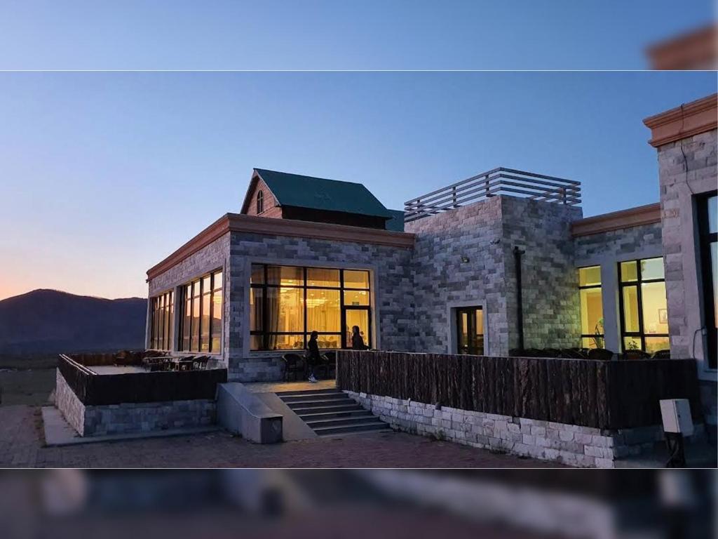 a large building with windows and a sunset at Hunnu Camp in Arhust
