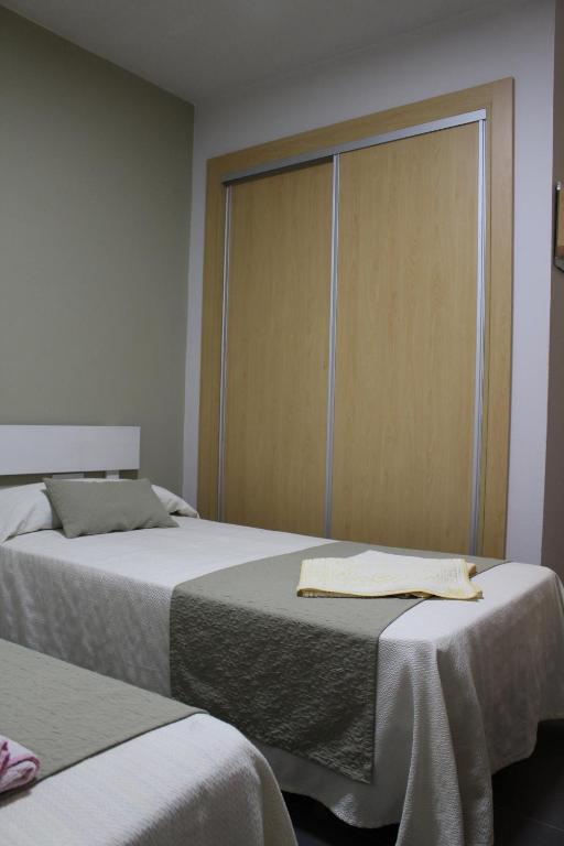 a bedroom with two beds and a sliding door at Apartamentos Bolonia Paraiso in Bolonia