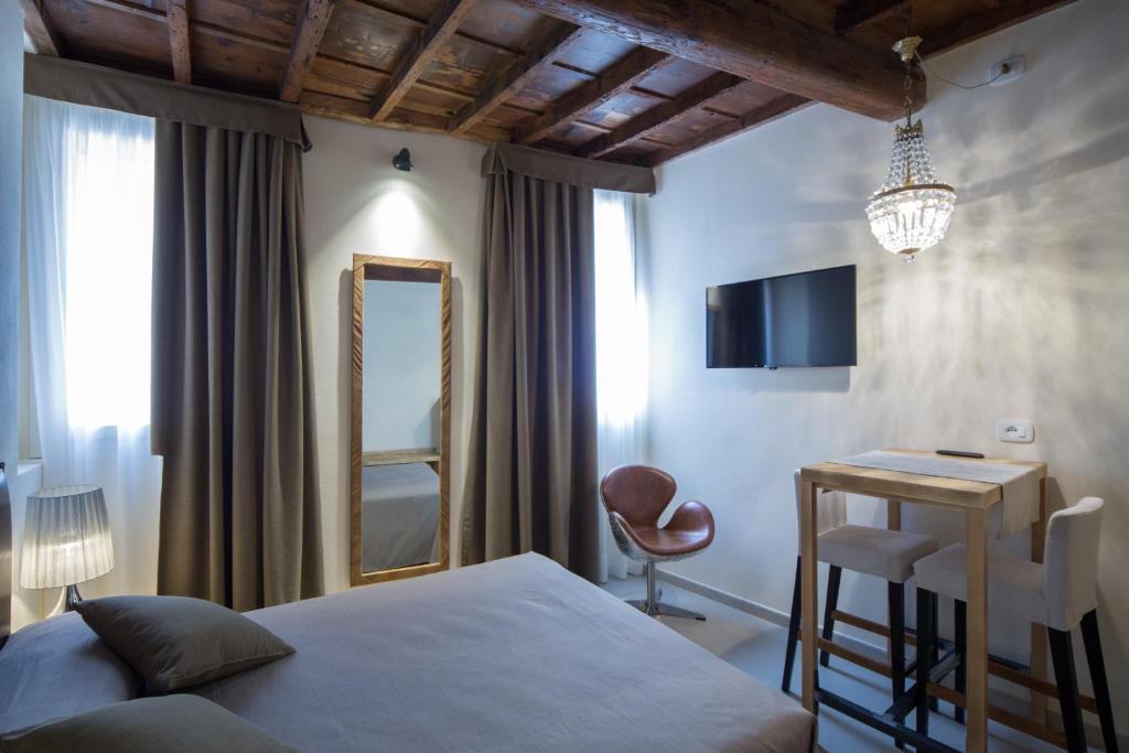 1 dormitorio con cama, escritorio y espejo en Studio 27, en Ferrara