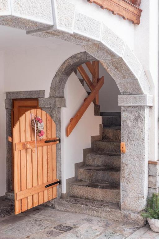 an entrance to a building with a wooden door and stairs at Cjase Cumine in Lauco