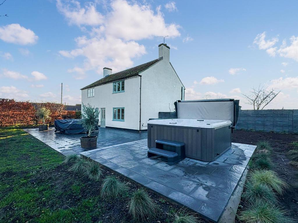 ein weißes Haus mit einem Whirlpool auf einer Terrasse in der Unterkunft Hill House - Uk49727 in Oxborough
