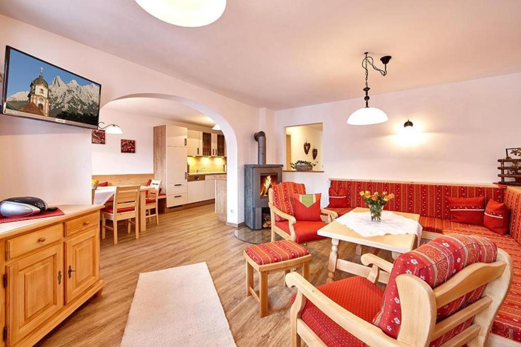 a living room with red furniture and a table at Landhaus Bergliebe in Mittenwald
