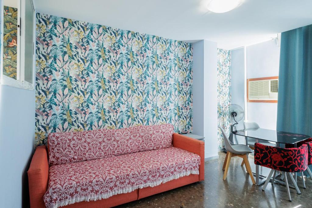 een woonkamer met een rode bank en een tafel bij Center Sevilla Magdalena Premium in Sevilla