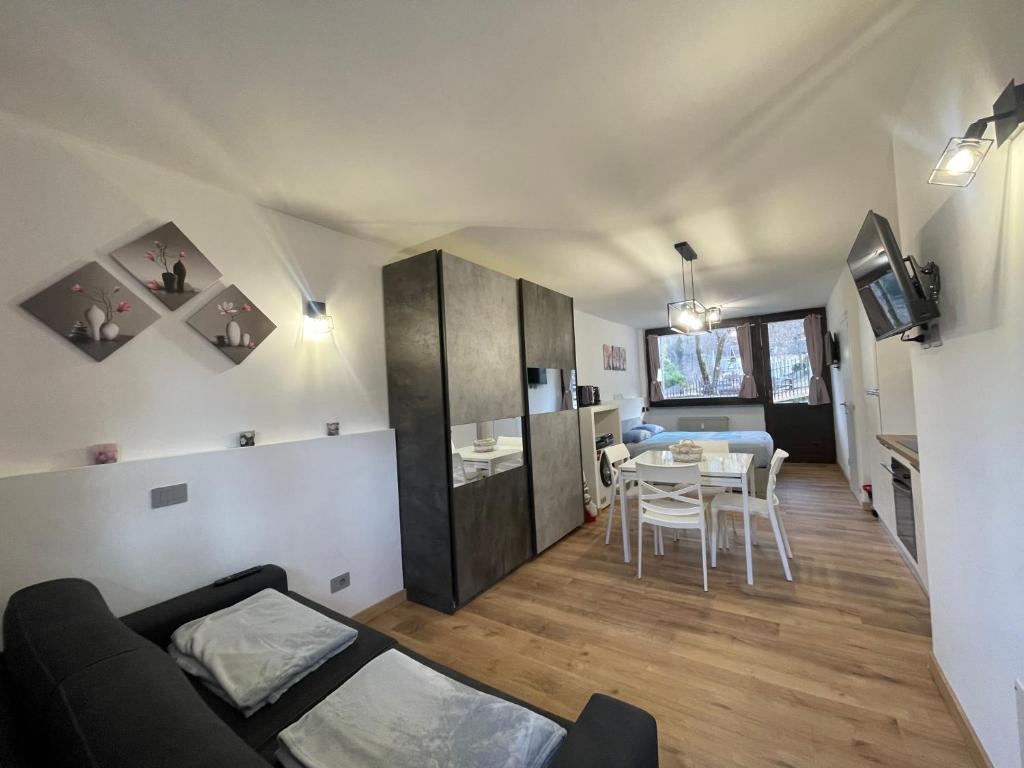 een woonkamer met een bank en een tafel bij La Casa di Paolo - Monolocale ristrutturato con vista sulle montagne in Caspoggio