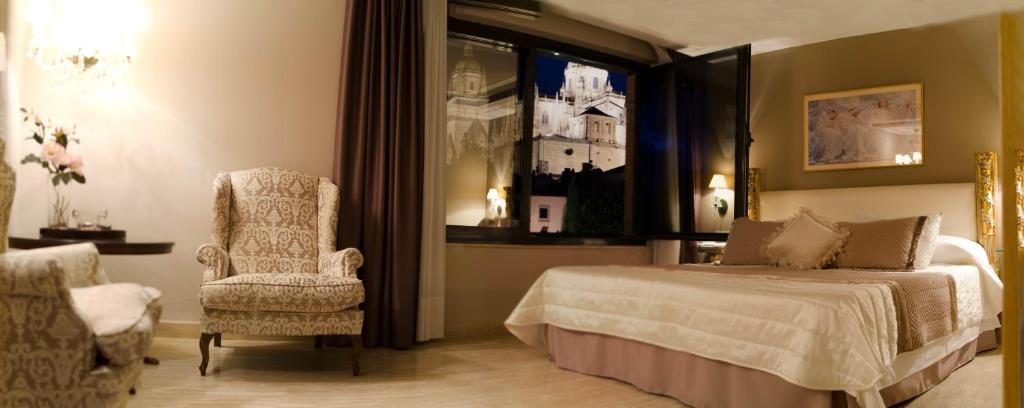 Un dormitorio con una cama y una silla y una ventana. en Hotel San Polo, en Salamanca