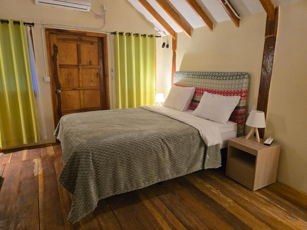 a bedroom with a bed and a wooden floor at J home stay in Maluk