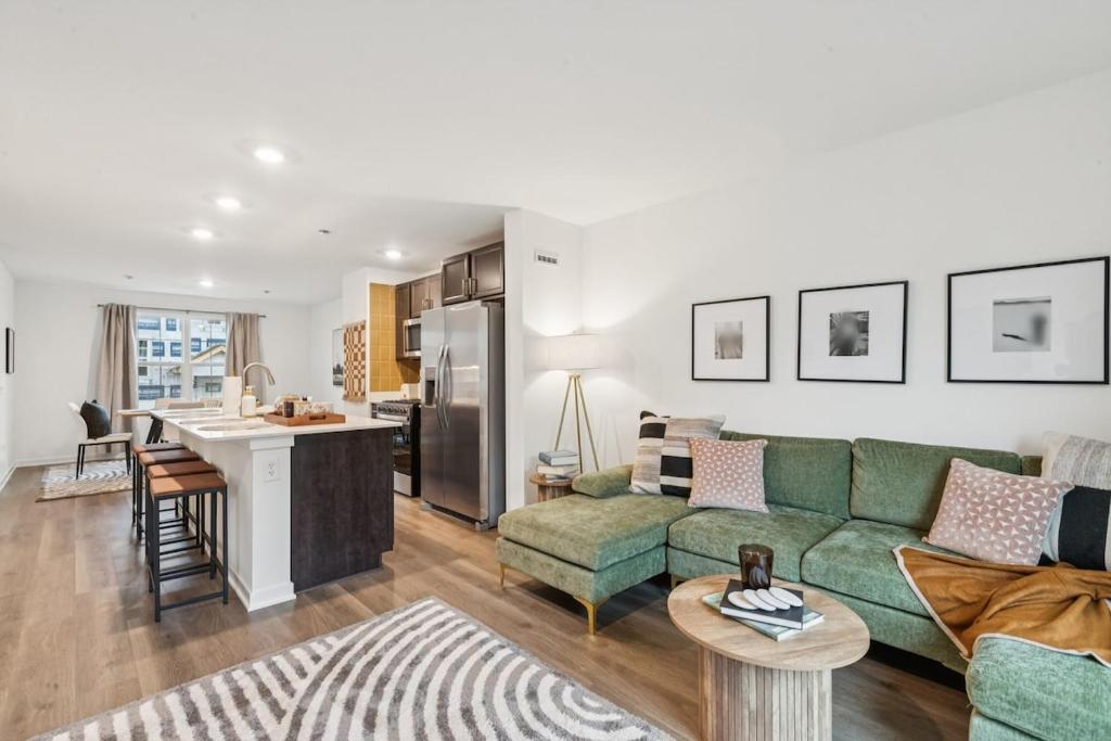 een woonkamer met een groene bank en een keuken bij The Wonder 