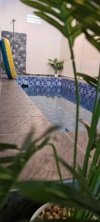 a house with a pool with a plant in the foreground at Marang Private Pool Homestay - 3-Bedroom - Family & Group Stay in Marang