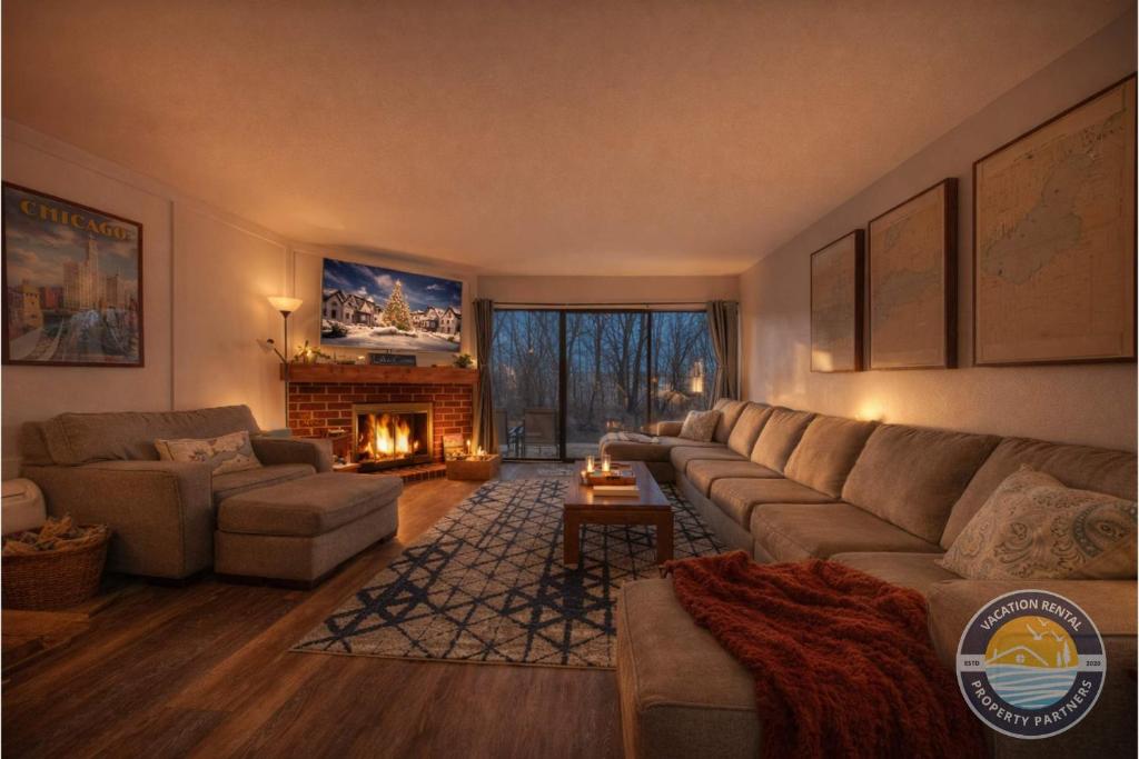 ein Wohnzimmer mit Sofa und Kamin in der Unterkunft Modern Lake Geneva Condo with Year-Round Views in Lake Geneva