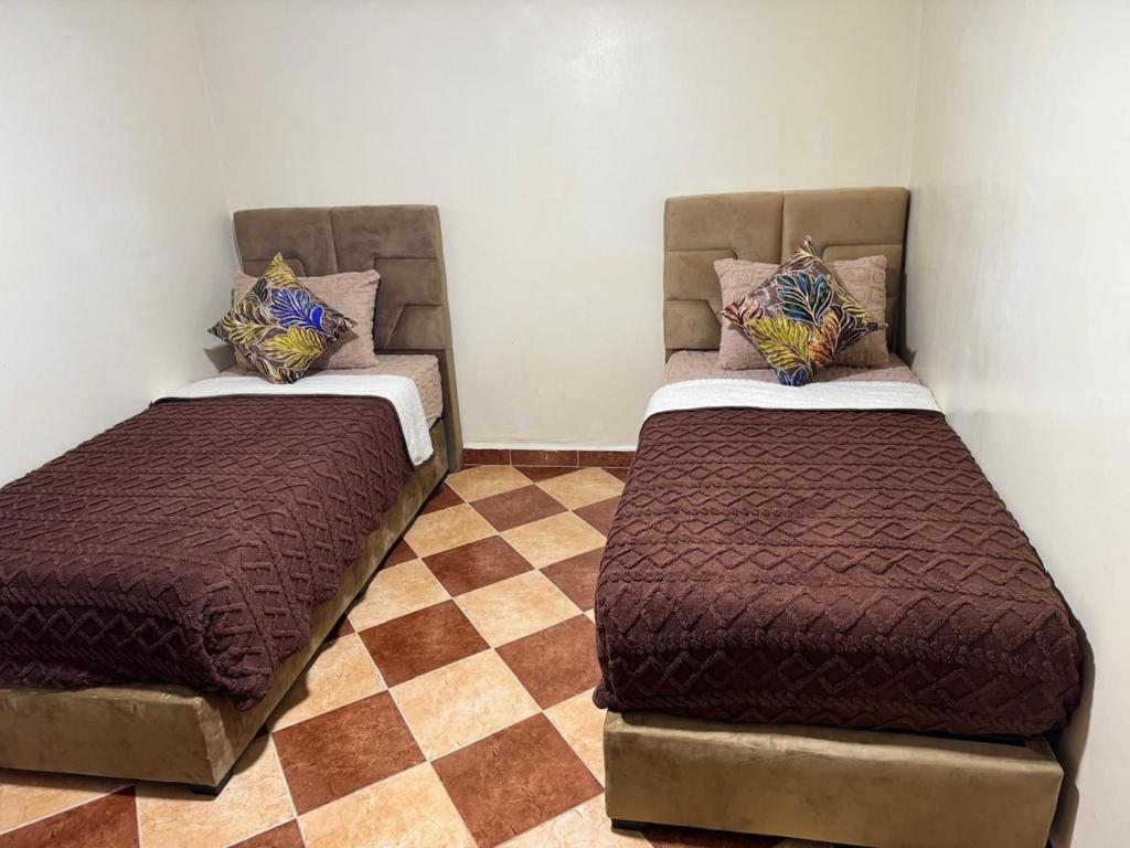 Dos camas una al lado de la otra en una habitación. en Dar Noor El Chams, en Oulad Akkou