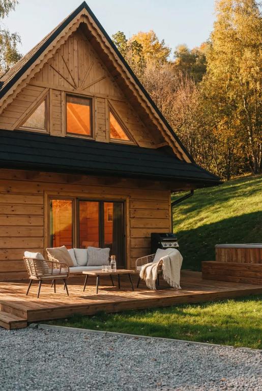 a log cabin with a living room and a patio at Domek w sam las in Ochotnica Dolna