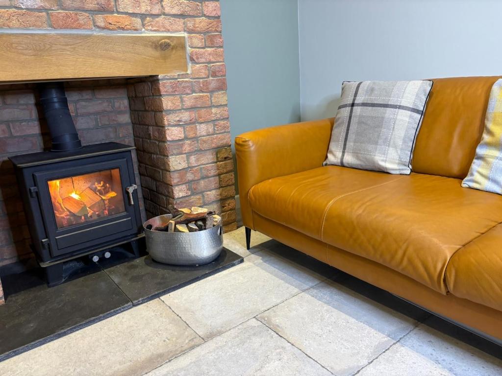 een bank in een woonkamer met een open haard bij The Old Pitman's house in Ollerton