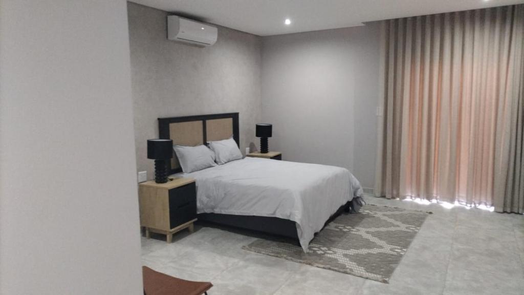 En eller flere senge i et værelse på Mupauli Boutique Lodge