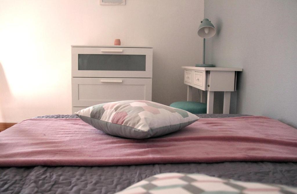 a bedroom with a bed with a pillow and a dresser at La Colombière - Montélimar in Montélimar