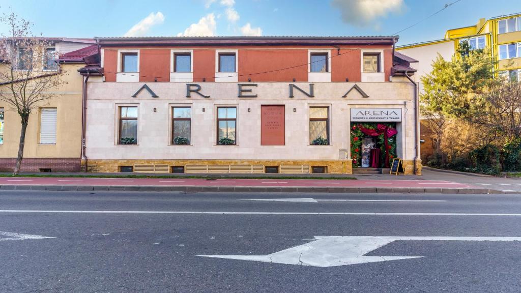 een oud gebouw in een straat met een pijl die naar een winkel wijst bij Pension Arena in Cluj-Napoca