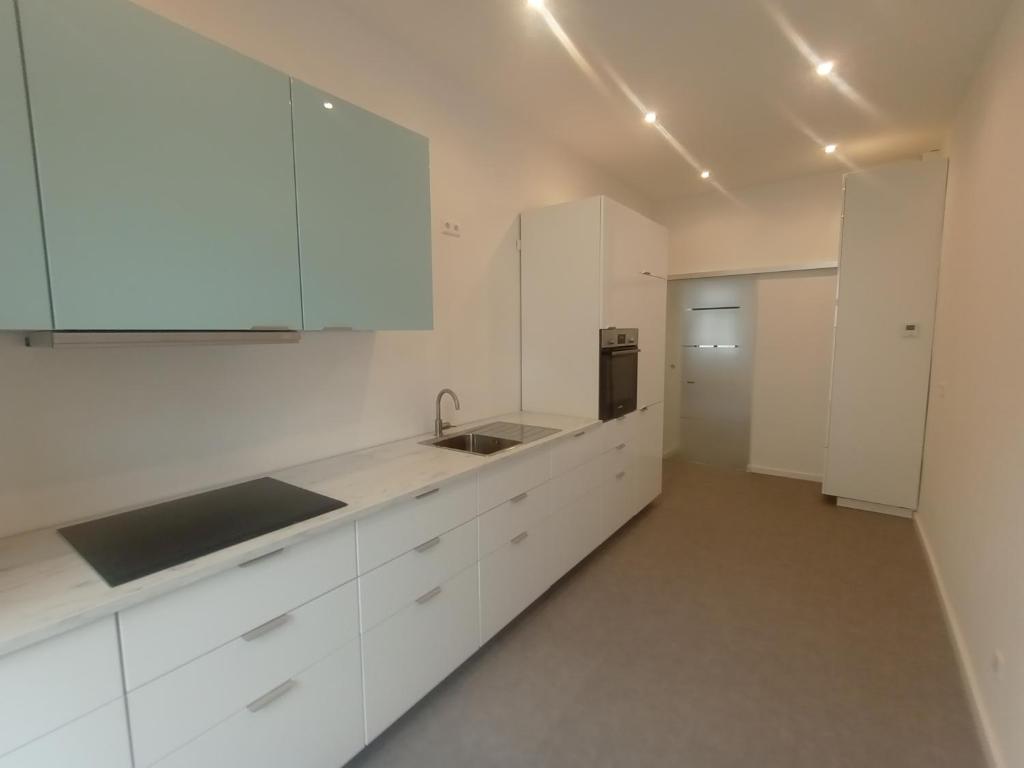 een witte keuken met witte kasten en een spoelbak bij Ferienwohnungen in der Kunstgalerie in Chemnitz