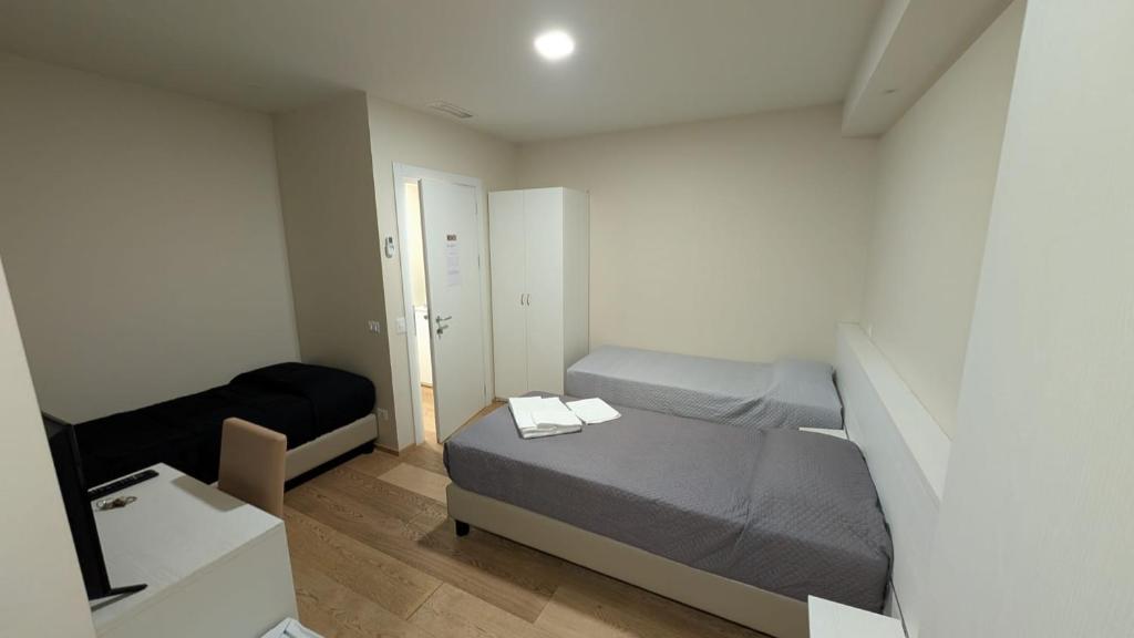 een kleine slaapkamer met een bed en een spiegel bij L'Ulivo in Almè