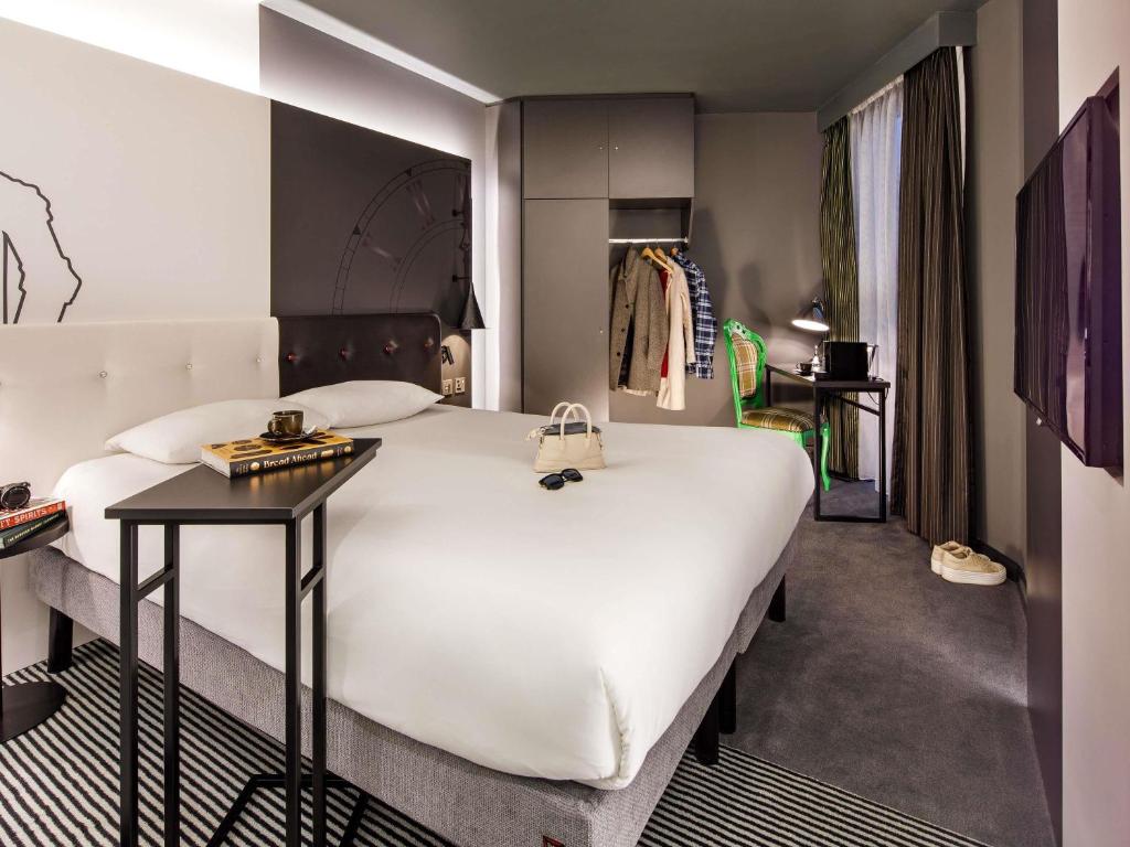 een slaapkamer met een groot wit bed en een tafel bij ibis Styles London Southwark - near Borough Market in Londen