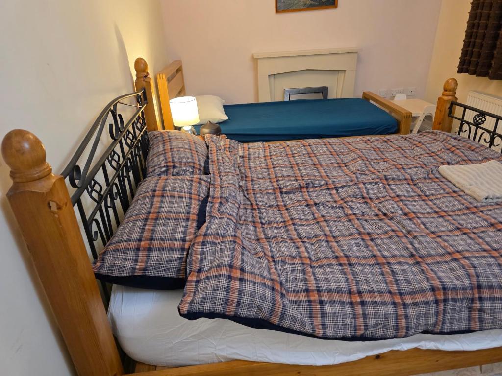um quarto com uma cama com um cobertor xadrez em Colchester Hythe home em Hythe