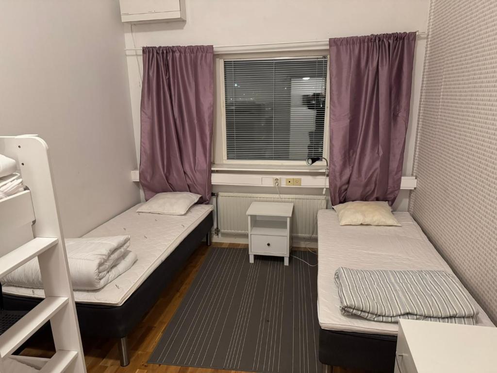 una piccola stanza con due letti e una finestra di Frövi vandrarhem a Frövi