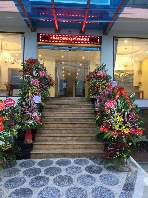 a set of stairs with flowers in front of a building at AVS Nội Bài Hotel in Sóc Sơn