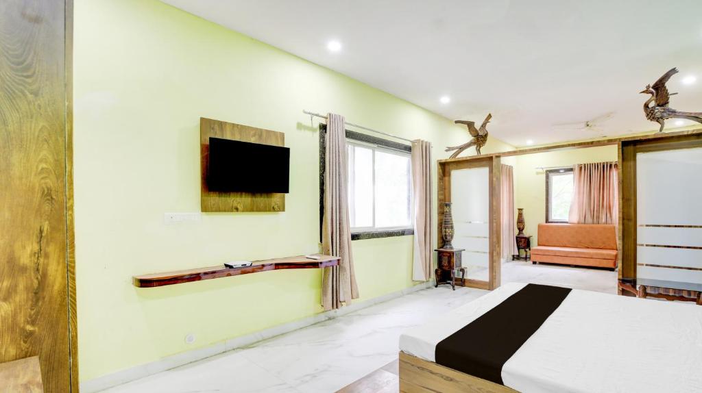 a bedroom with a bed and a tv on the wall at SPOT ON Parampara Garden Resort in Shamsgarh