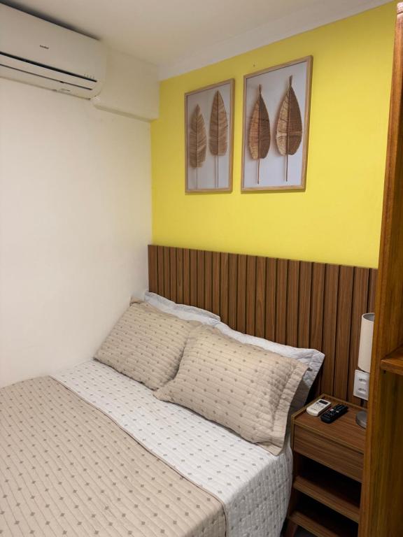a bedroom with a bed and two pictures on the wall at Apartamento do Padin 2-2ª Praia in Morro de São Paulo