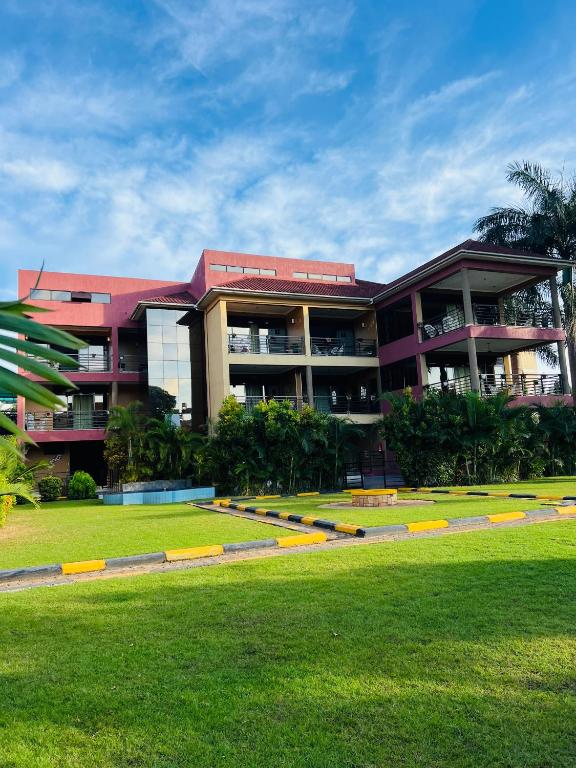 a building with a lawn in front of it at Las Vegas Garden Hotel-Kampala in Kampala
