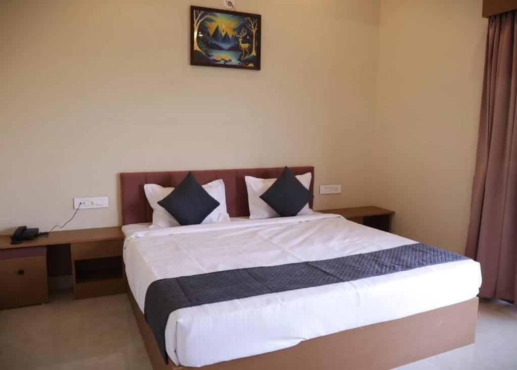 a bedroom with a large bed with black and white pillows at The Rukmani villas in Jāmb