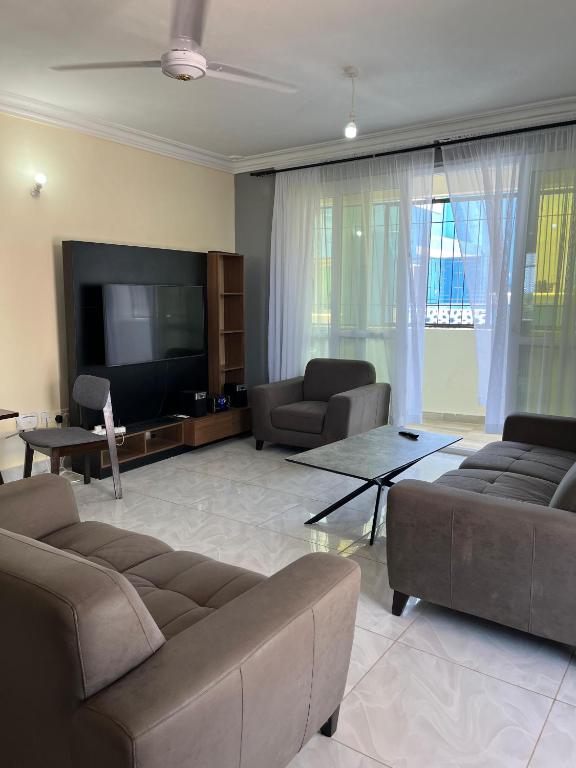 a living room with couches and a flat screen tv at Goodlifehomes in Mtwapa
