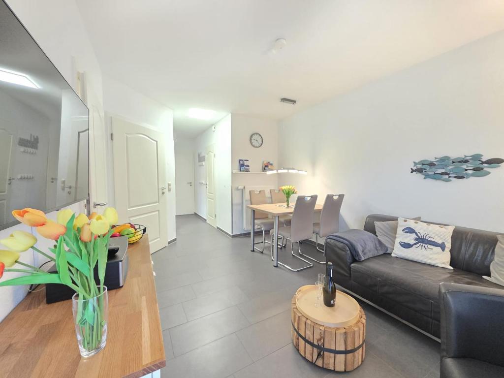 a living room with a couch and a table at Ferienwohnung KüstenSAND in Norden